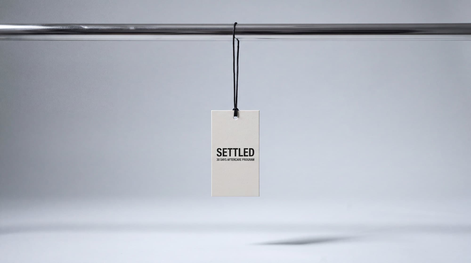 Cardboard tag hanging from a chrome bar: Settled, 30 days aftercare program